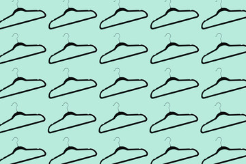 Pattern of black hangers isolated on background of aqua menthe color.