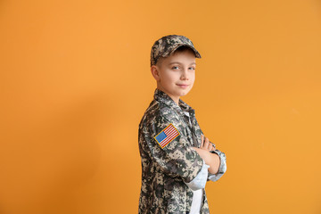 Cute little soldier on color background