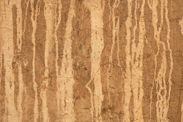 old yellow wall with cracks and peeling white paint. rough surface texture