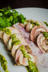 rolls of herring fish and soft cheese with pesto
