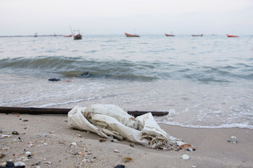 Dirty sand shore with plastic sack, Environmental pollution. Ecological problem, Background sea and...