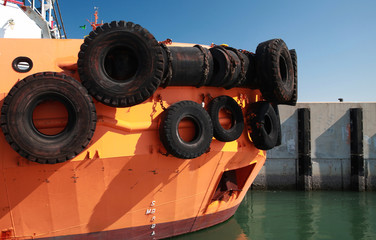 Bow of a tug boat with  bright orange hull