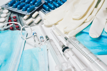 Fototapeta premium Medical equipment. Coronavirus protection. Medical face mask. Sterile gloves. Syringe and drugs. Doctor uniform for patient treatment in hospital. Prevention the spread of COVID-19.