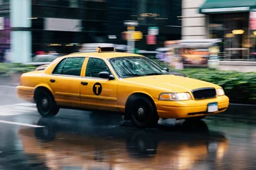 Foto op Plexiglas New York taxi Gele taxi rijdt door de straten van New York op een regenachtige dag. Dynamische afbeelding