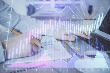 Multi exposure of stock market graph with man working on laptop on background. Concept of financial analysis.