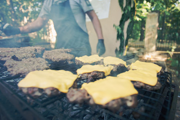 The process of cooking grilled cheeseburgers close-up, blurred background