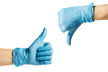 Hands in a medical glove show thumb up down . On a white isolated background - 334973495