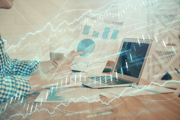 Double exposure of financial graph with man works in office on background. Concept of analysis.