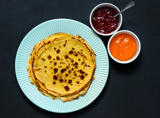 Homemade pancakes, good dessert with apricot and strawberries jam