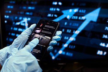 COVID-19 self-quarantine. Businessman checks the news on a smartphone during coronavirus pandemic