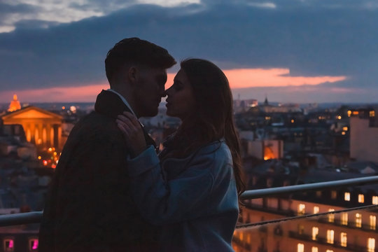 love, couple kissing on night city skyline view, romantic honeymoon in Paris, France