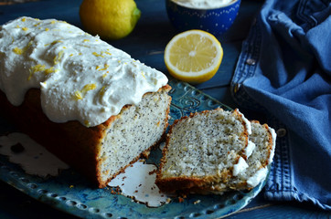 Sliced lemon pie with poppy seeds on a blue wooden background