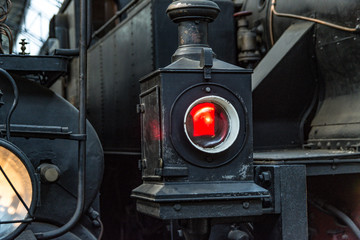 detail of the red lantern of an old steam train machine