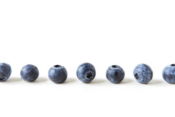 a line of blueberries on white background