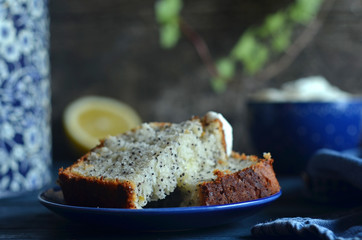 Pieces of lemon cake with poppy seeds on a saucer on a blue background