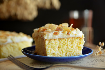 A piece of milk Arabic cake with almonds on a blue plate