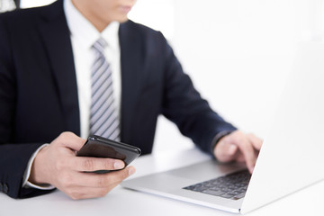 スマホのデータを入力する日本人男性ビジネスマン