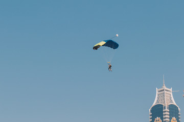 People fly with a parachute in the blue sky