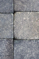 Stone background close-up. Natural texture. Light gray bluish backdrop or wallpaper. Rough surface. Reduced contrast. Vertical shot. Macro