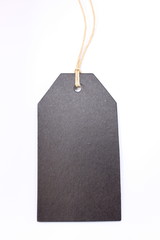 A photograph of a black paper price tag, blank, with space for text. Isolated against a white background
