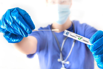 eine Ärztin hält ein Abstrichröhrchen mit Coronavirus in der Hand