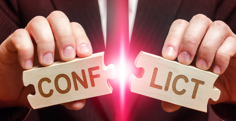 Man breaks puzzles with word Conflict. Dispute solution , compromise consensus. Overcoming barrier...