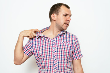 Closeup portrait of young man opening shirt to vent,it's hot. Negative emotion, facial expression,...