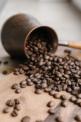 Turkish coffee pot full of coffee beans on wooden board