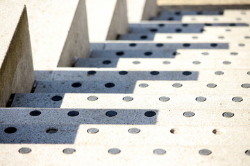 A photograph of shadows on white stone steps, with non-slip patches.  Outdoor public architecture design