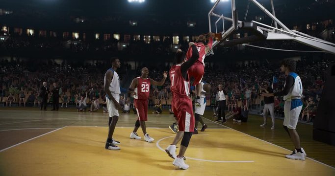 Basketball player scores a goal with splashes and flames animation on a professional basketball stadium. Stadium is made in 3d with animated crowd.