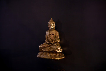small figurine of Buddha on a black