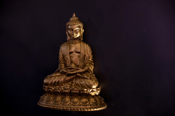 Fototapeta na wymiar small figurine of Buddha on a black