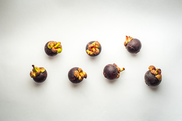 Seven Entire Mangosteen (Garcinia Mangostana) Fruits on a White Background