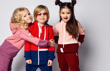 Frolic kids curly hair blonde girl, her brother blond boy and thier friend brunette girl pose...