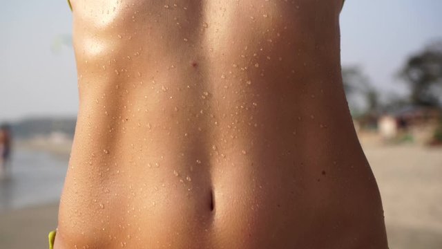 Young sexy woman on the beach in a bikini. Girl in a swimsuit, close-up