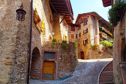 Beautiful medieval village near the lake Lago di Garda, hisoric village in the mountains with houses with stone walls and flowers in the windows, cobbled streets