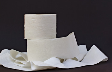 Toilet paper on black background. Toilet paper crisis because of Corona. Bottleneck.