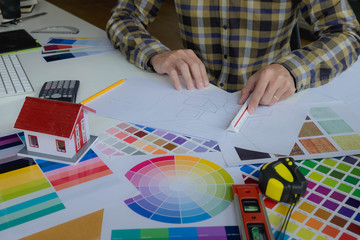 Engineers and creative artists work on table, work, consult, advise on choosing colors and...