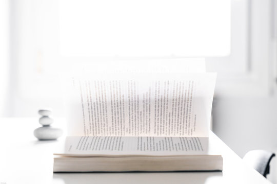 Open Book With Loose Pages On A Desktop With A Window Light In The Background