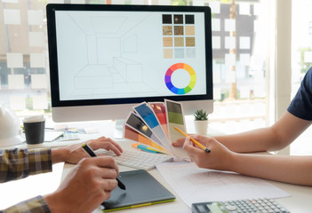 Engineers and creative artists work on table, work, consult, advise on choosing colors and...