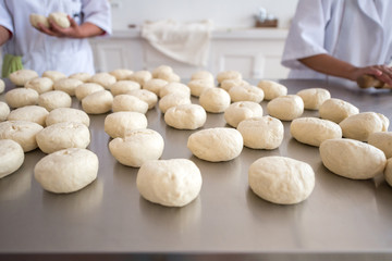 Fototapeta na wymiar Brown Women Using a White Food Uniform is Making Bread with Flour Dough