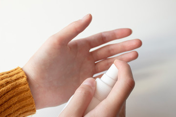 The girl sprays a decontaminating agent on the wound. Treatment of hands with an antiseptic....
