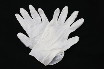 Pair of two medical white rubber gloves on black background. Disposable gloves concept for health...