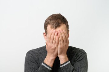  man covers his face by hand