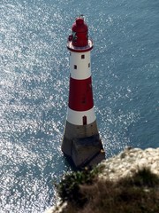 Beachy head lighthouse at high tide surrounded by nice reflections and glare.