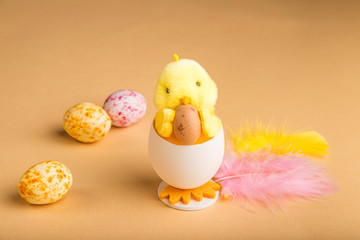 Easter background with beige marzipan Easter eggs, chick and spring flowers