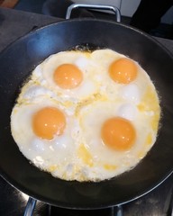four fried eggs in cast iron pan, directly above