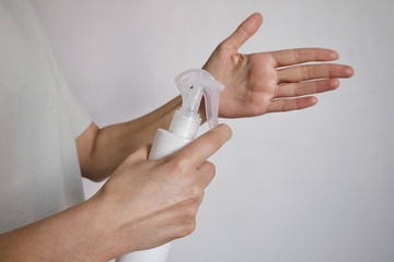 Woman in medical gloves holds a disinfectant spray. Protecting body from viruses and bacteria. Hand hygiene, sterile uniform. The fight against epidemic. Safety for your life. Prevention and control