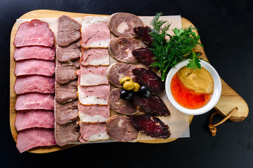 Set mix jerky, sausage, salami and bacon served on a wooden board