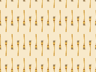 top view of golden forks isolated on beige, seamless background pattern